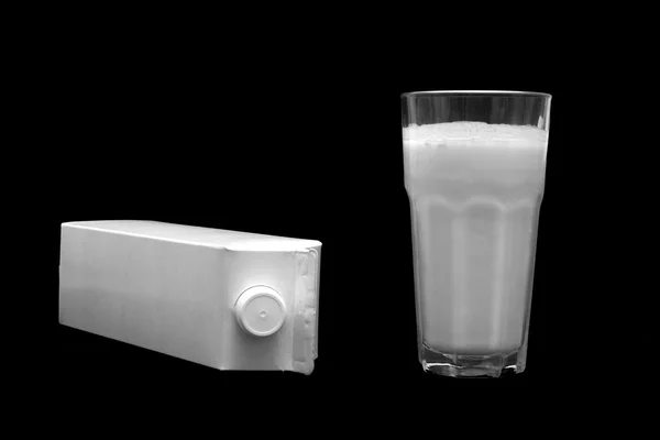 Boîte à lait blanche et un verre de lait — Photo