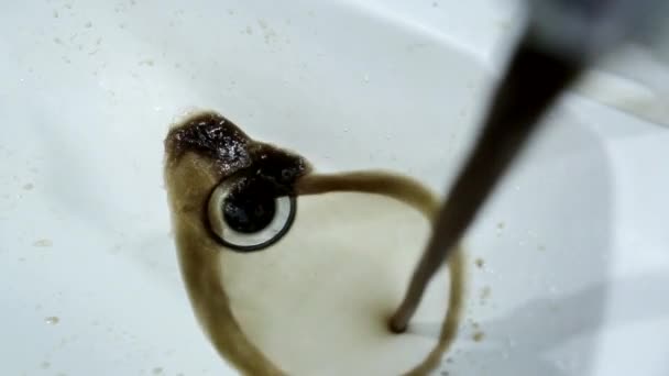 Ржавая и грязная вода течет из крана в раковину. Очистка водопроводной воды, ремонт водопровода, промышленность — стоковое видео
