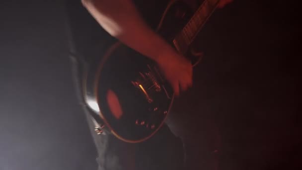 Мужчина гитарист играет на электрическом басу на концерте. Фон музыкального инструмента, крупный план, динамика — стоковое видео