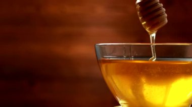 Bir kasedeki lezzetli ve sağlıklı bal bal bal için ahşap bir çubuktan aşağı akıyor, kopyalama alanı, organik