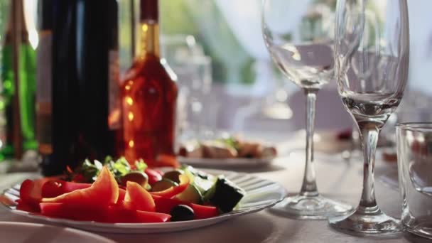 Schöne Tischdekoration bei einem Bankett, Flaschen mit Alkoholgläsern stehen auf einem dekorierten Tisch vor dem Hintergrund der Sonne — Stockvideo
