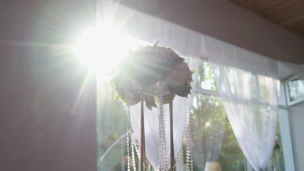 Букет квітів з прикрасами на фоні сонця у вікні. Декорування для прикраси банкетного залу — стокове відео