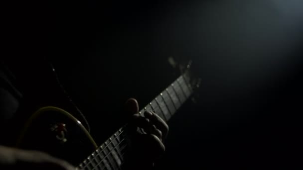 Мужчина гитарист играет на электрическом басу на концерте. Фон музыкального инструмента, крупный план — стоковое видео