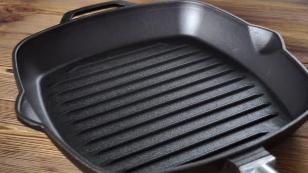 Öntött vas grill serpenyő kivehető fa fogantyú fa háttér. Finom és egészséges főzési koncepció, konyhai eszközök — Stock videók