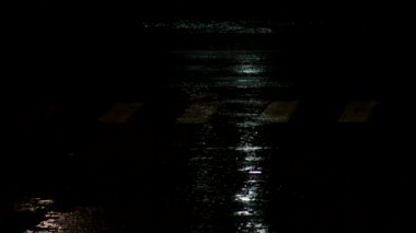 Gece şehrinin birikintisinde yağmur damlaları, arka plan. Şehir boyunca sağanak yağmur yağıyor, açık havada.