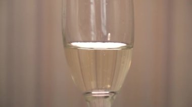 Yanıp sönen ışığı yansıtan bir kadeh şampanya, yakın plan. Şampanya köpükleri