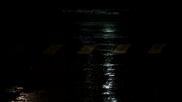 Regendruppels in een plas van de nachtstad, achtergrond. Zware regenval valt door de stad, buiten — Stockvideo