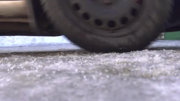 Remafstand van een auto op ijs en sneeuw in de winter. Winterbanden concept, close-up — Stockvideo