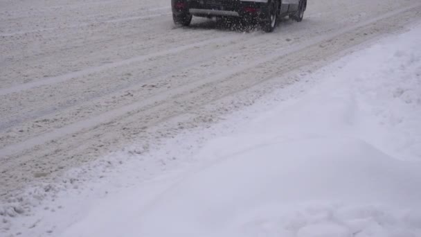 Bilar kör på en snöig väg i staden, slow motion. Transport, vinterdäck, slow motion — Stockvideo