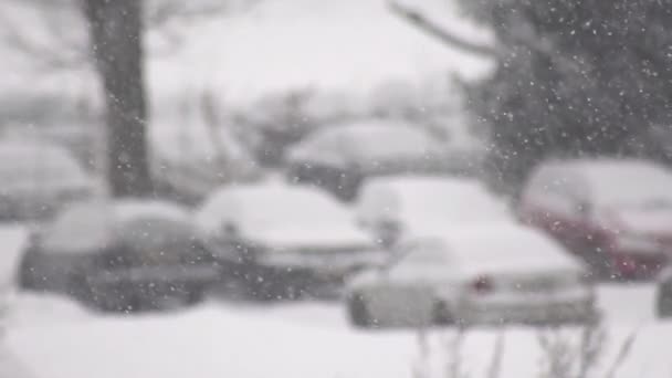 Las fuertes nevadas en invierno en el fondo de un estacionamiento con coches, espacio de copia. En cámara lenta, ventisca — Vídeos de Stock