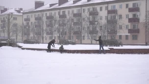 人们在雪地里打雪球，在冬城散步，动作缓慢。室外 — 图库视频影像