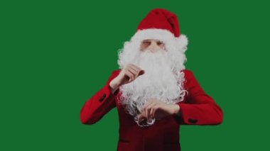 Noel Baba gibi bir adam yeşil ekran krom arka planında dans eder. Noel ve Yeni Yıl konsepti. İndirim, promosyon, satış. Beyaz sakallı ve kırmızı şapkalı adam..