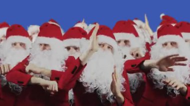 Birçok Noel Baba mavi perde arkasında dans eder. Noel ve Yeni Yıl konsepti. Beyaz sakallı ve kırmızı şapkalı kalabalık Chromakey 'de. Takım ve grup. İndirim ve promosyon, satış