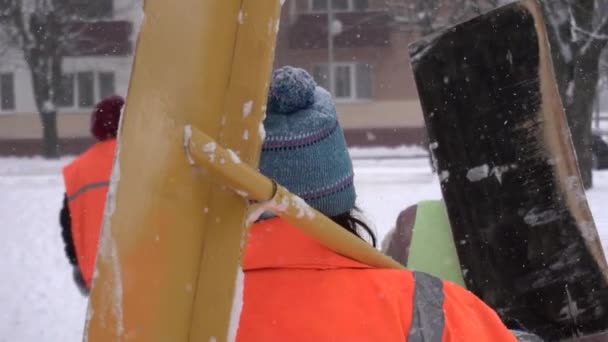 市内にシャベル付きの清掃員のグループは、冬に雪を取り除くために行きます,遅いモ.雪の除去 — ストック動画