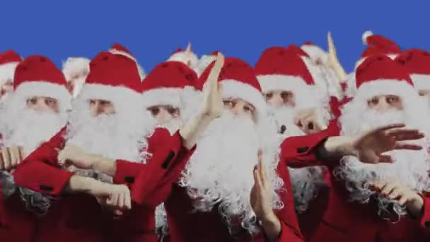 Molte clausole di Babbo Natale ballano su sfondo blu. Natale e Capodanno concetto. La folla in barba bianca e cappello rosso sono su Chromakey. Squadra e gruppo. Sconti e promozioni, vendite — Video Stock