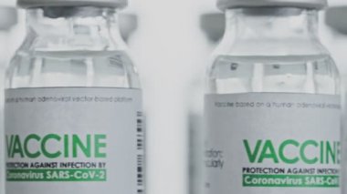 Döngülü. COVID-19 koronavirüs tedavisi için şişeler yavaş yavaş araştırma laboratuarında değiştiriliyor. Aşı, iğne, salgın sırasında klinik deney. Şişeler, şişeler saat yönünün tersine dönüyor. Makro