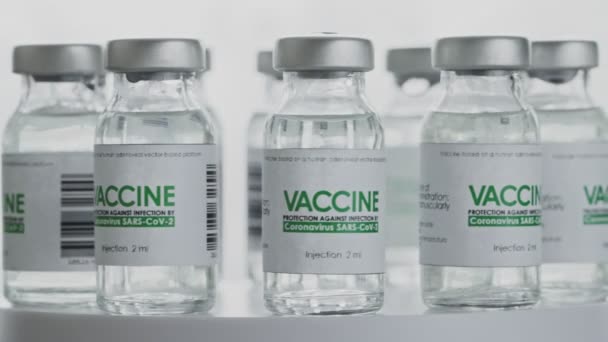 Bouclée. Les flacons de vaccin contre le coronavirus COVID-19 sont lentement tournés en laboratoire de recherche. Vaccination, injection, essai clinique pendant la pandémie. Bouteilles, flacons tournent dans le sens des aiguilles d'une montre. macro large — Video