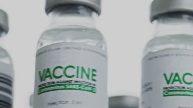 COVID-19 koronavirüs tedavisi için gereken aşı flakonları hızlı ve yavaş bir şekilde araştırma laboratuarına gönderiliyor. Salgın sırasında aşı enjeksiyonu klinik deneyi. Şişeler yavaşça saat yönünde dönüyor. Makro