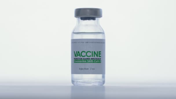 在研究实验室，交上防护医用手套，用注射器从用于治疗头孢病毒COVID-19的疫苗瓶中注射。疫苗接种概念，大流行病。宏观。Vial在前头 — 图库视频影像