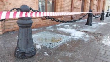 Şehirde, buz ve buz saçaklarının düştüğü çatıdan gelen kırmızı ve beyaz uyarı bandı var. Yaralanma riski, hava durumu