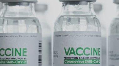Döngülü. COVID-19 koronavirüs tedavisi için yapılan aşılar araştırma laboratuarında yavaşça döndürülmektedir. Aşı, iğne, salgın sırasında klinik deney. Şişeler, şişeler saat yönünde dönüyor. Kapanış makrosu