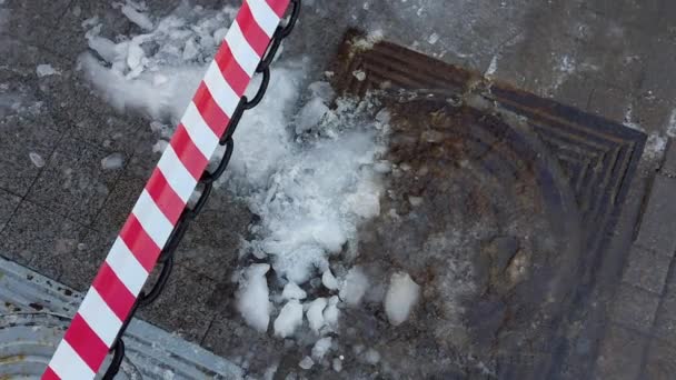 Natte sneeuw met ijs en ijspegels ligt op de stoep die van het achterdak is gevallen. Waarschuwingstape om verwondingen door ijspegels te voorkomen, buiten — Stockvideo