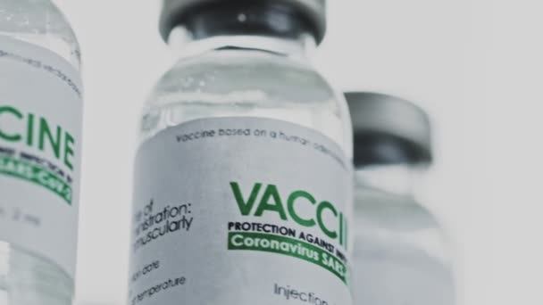 Hurok. A COVID-19 koronavírus gyógyítására szolgáló vakcinát tartalmazó injekciós üvegek lassan forognak a kutatólaborban. Vakcinázás, injekció, klinikai vizsgálat a világjárvány idején. Flacons, az injekciós üvegek az óramutató járásával megegyező irányban forognak. Szoros makró — Stock videók