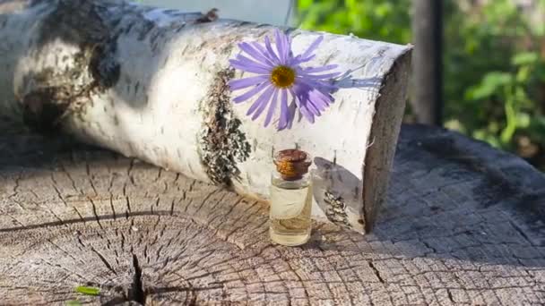 Fles met blauwe kamille etherische olie op een houten ondergrond, aromatherapie — Stockvideo