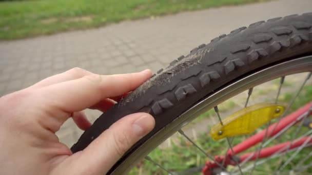 En cyklist rullar en cykel med en platt, punkterad hjul, närbild. Stansat hjulrör, industri — Stockvideo