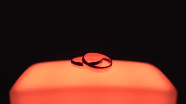 Обручальные кольца для свадьбы на многоцветном мигающем фоне, крупным планом. — стоковое видео