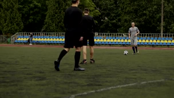 Přátelé hrají fotbal a dávají si propustku. Fotbal amatér hra v malém stadionu. Trénink. Tým přátelský zápas. Sport — Stock video