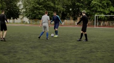 Futbolcu pas veriyor, takım arkadaşına pas veriyor. Arkadaşlar futbol oynar. Beklenmedik manevra, aldatıcı hareket. Küçük bir stadyumda amatör bir maç. Egzersiz eğitimi. Takım maçı. Spor.