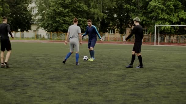 Jugador de fútbol da un pase lob, cruzar a su compañero de equipo. Los amigos juegan al fútbol. Maniobra inesperada, movimiento engañoso. Juego amateur en un pequeño estadio. Entrenamiento de entrenamiento. Partido de equipo. Deporte — Vídeos de Stock