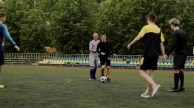 Futbolcu saldırır, top sürme numarası yapar ve takım arkadaşına pas verir. Beklenmedik futbol manevrası, aldatıcı hareket. Küçük stadyumda amatör bir maç. Egzersiz eğitimi. Takım maçı. Spor.
