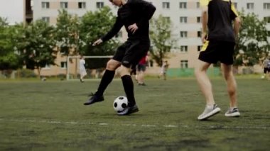Futbolcu top sürme numarası yapıyor, takım arkadaşına pas veriyor, topu atıp hokkabazlık yapıyor. Beklenmedik futbol manevrası, aldatıcı hareket. Amatör bir oyun. Egzersiz eğitimi. Takım maçı. Spor.