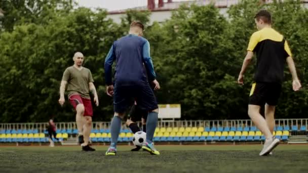 Freunde spielen Fußball und geben sich gegenseitig einen Pass. Fußball Amateurspiel in einem kleinen Stadion. Trainingstraining. Freundschaftsspiel. Freizeit — Stockvideo