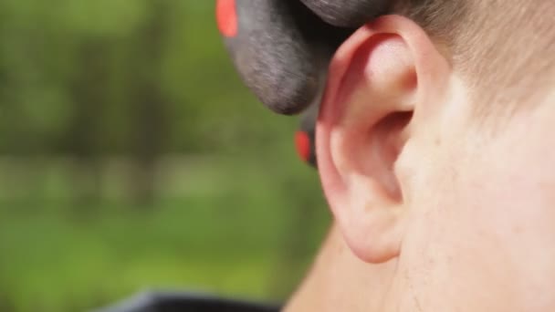 한 남자가 귀에 귀마개를 꽂고 닫습니다. 청각 보호와 안전 개념 — 비디오