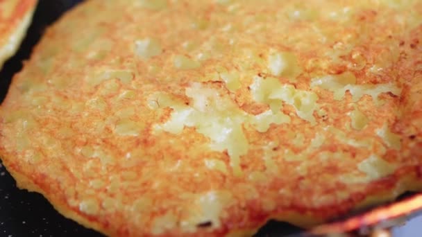 Kartoffelpuffer werden in einer Pfanne gebraten, goldene Kruste. Leckeres traditionelles Essen, Makro. — Stockvideo