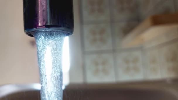L'eau coule du robinet sur fond de soleil. Concept d'économie et de consommation d'eau, tarif et prix de l'eau. Espace de copie pour le texte — Video