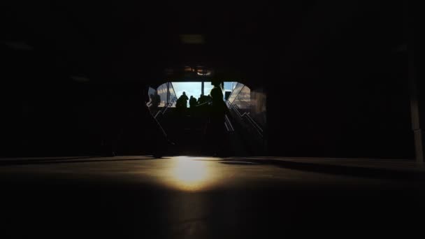 Folk går genom mörka gångtunneln nära trappor vid Susnet, tunnelbana passage, tunnelbana. Silhuett. Korridor till tunnelbanan. Resor och stadsliv, abstrakt — Stockvideo