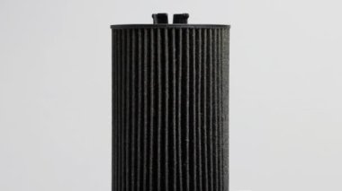 Araba yağı filtresi beyaz arka plana yerleştirildi. Topraktan ve kirlilikten yağ temizleme kavramı, makro