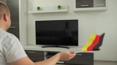 Spor taraftarı evinde TV karşısında oturuyor, Almanya bayrağını sallıyor ve Yaz Kış Oyunları 'nda milli takımın zaferini kutluyor. Adam dünya şampiyonası kupasının yayınını izliyor. Kazan.