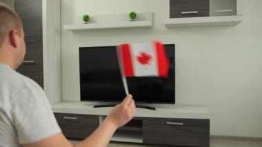 Spor fanatiği evde TV karşısında oturur, Kanada bayrağını sallar ve Yaz Kış Oyunları 'nda milli takımın zaferini kutlar. Adam dünya şampiyonası kupasının yayınını izliyor. Kazan.