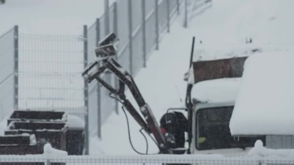 Samec sběrače odpadků ve městě provozuje v zimě hydraulické rameno v popelářském voze. Koncept městského sběru odpadků, pozadí. Rozmazané, kopírovací prostor pro text, industriální — Stock video