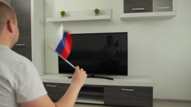 Spor fanatiği evde televizyon karşısında oturur, Rusya bayrağını sallar ve Yaz Kış Oyunları 'nda milli takımın zaferini kutlar. Adam dünya şampiyonası kupasının yayınını izliyor. Kazan.