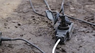 Fişi olan bir uzatma kablosu nemli zeminde yatıyor. İşlem sırasında güvenlik kavramı, elektrik şoku