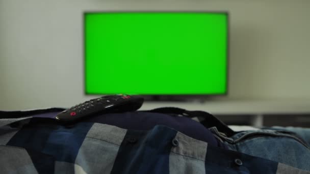 O homem está dormindo, o controle remoto da TV está deitado em seu estômago. Slumber. Crónico de ecrã verde. Dorme. Fadiga, cansaço. Guy está deitado no sofá no quarto em casa e não assistindo TV — Vídeo de Stock