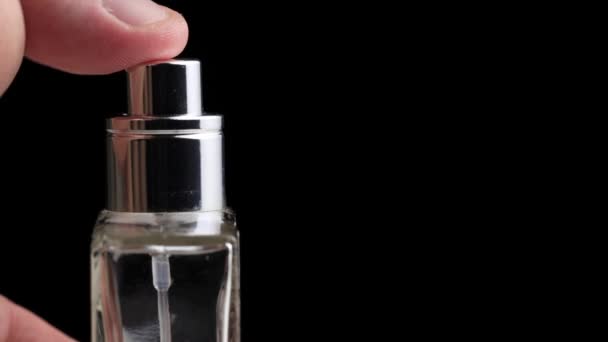 La mano del hombre presiona el difusor de perfume sobre un fondo negro. Copiar espacio para texto, primer plano, aroma — Vídeo de stock