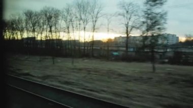 Trene binerken güzel turuncu gün batımı, pencereden manzara. Doğa ve ormanlar, şehir köyü. İlkbahar