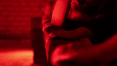 Birçok insan, koyu kırmızı bir odada, korkunç bir çevreye sahip bir tahta bloğa çekiçle vuruyor. Psikiyatrik manyaklar konsepti, protestosu, yakın çekim